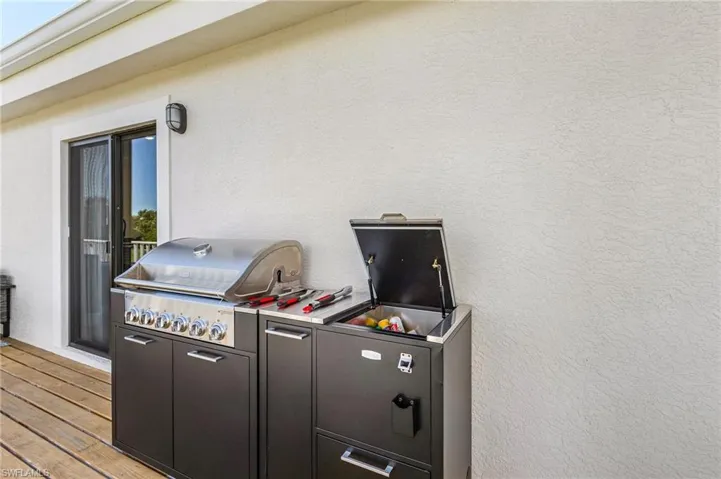 Wooden deck featuring area for grilling