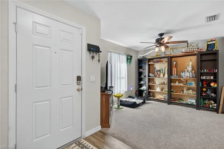Foyer entrance featuring wood finished floors, a ceiling fan, and carpet floors