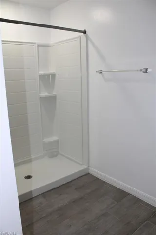 Bathroom with wood finished floors and a shower stall