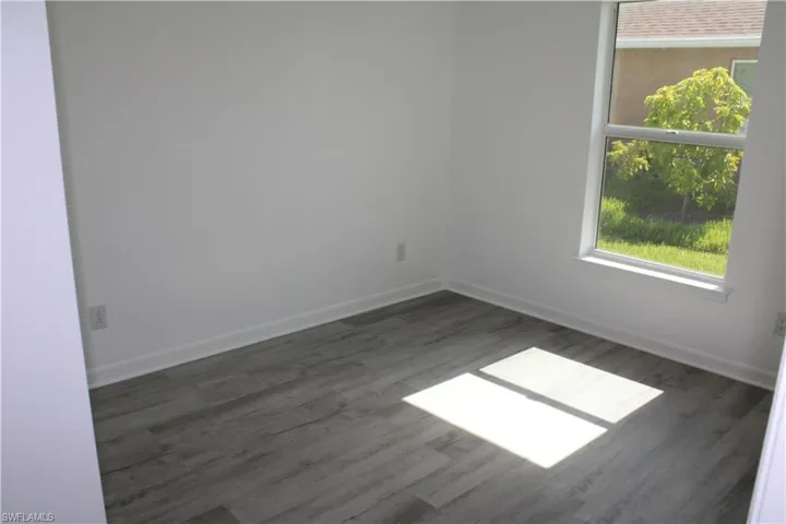Unfurnished room featuring wood finished floors and baseboards