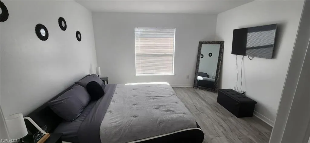 Bedroom with light wood finished floors and baseboards
