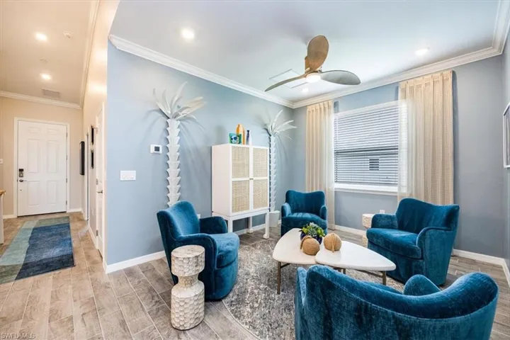 Sitting room featuring ceiling fan, ornamental molding, and light hardwood / wood-style flooring