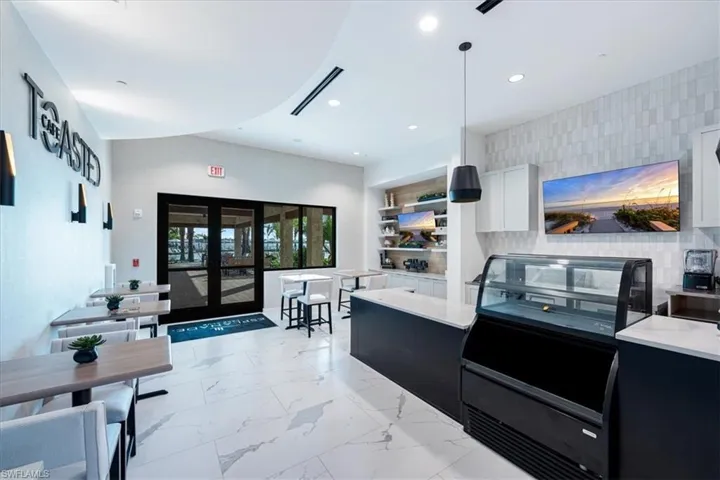 Kitchen featuring french doors, backsplash, hanging light fixtures, and white cabinets