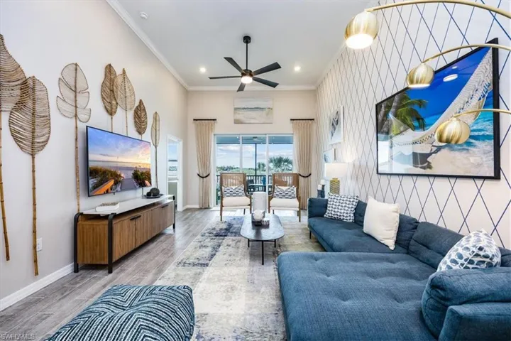 Living room featuring hardwood / wood-style flooring, ceiling fan, and crown molding