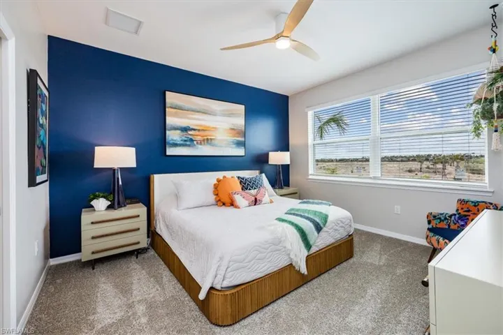 Carpeted bedroom featuring ceiling fan