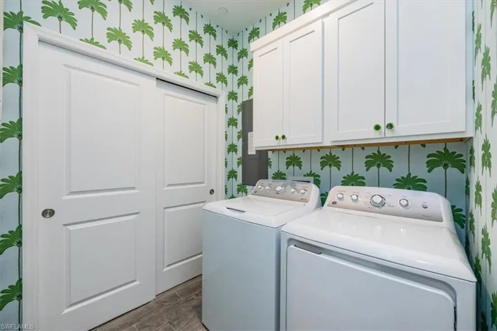 Laundry room featuring cabinets and washing machine and clothes dryer