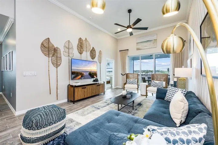 Living room featuring hardwood / wood-style floors, ornamental molding, and ceiling fan