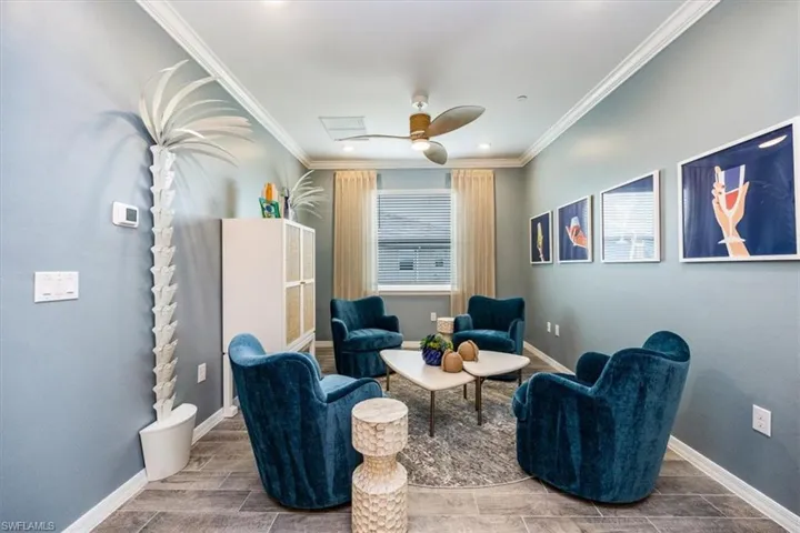 Living area featuring crown molding and ceiling fan
