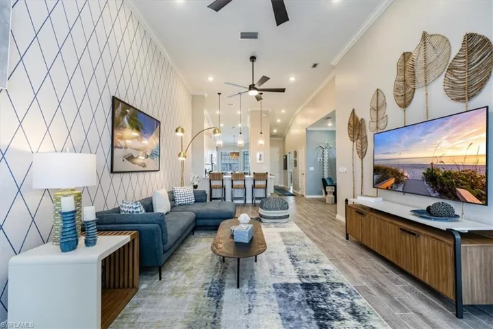 Living room with ceiling fan and ornamental molding