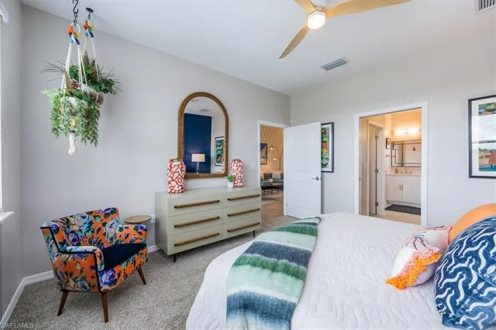 Bedroom with ceiling fan, ensuite bathroom, and carpet