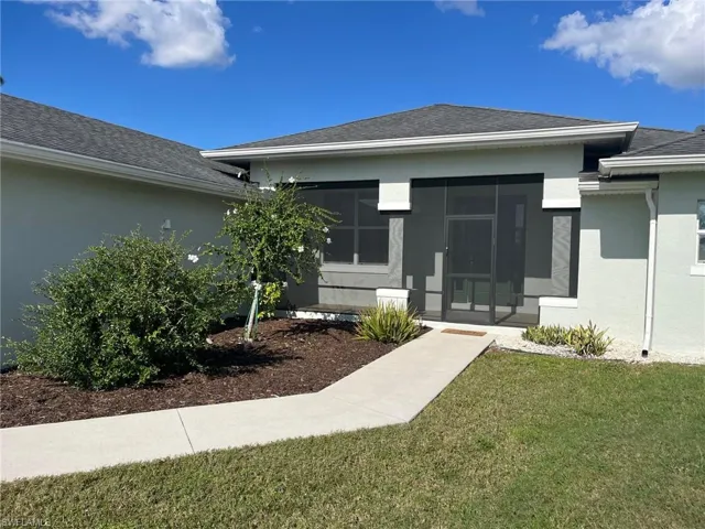 View of exterior entry featuring a yard