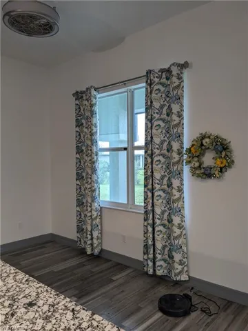 Empty room with dark hardwood / wood-style floors