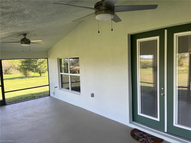 Unfurnished sunroom featuring lofted ceiling and ceiling fan