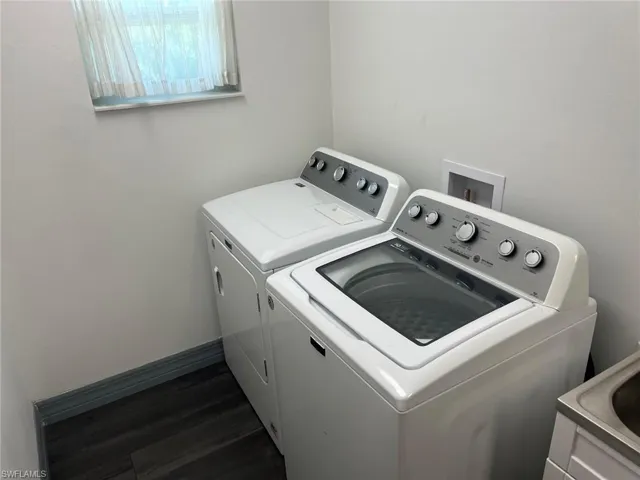 Washroom with separate washer and dryer and dark hardwood / wood-style flooring