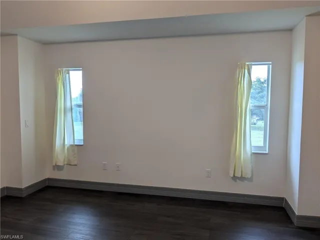 Empty room with dark wood-type flooring