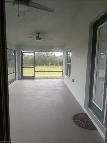 Unfurnished sunroom featuring ceiling fan