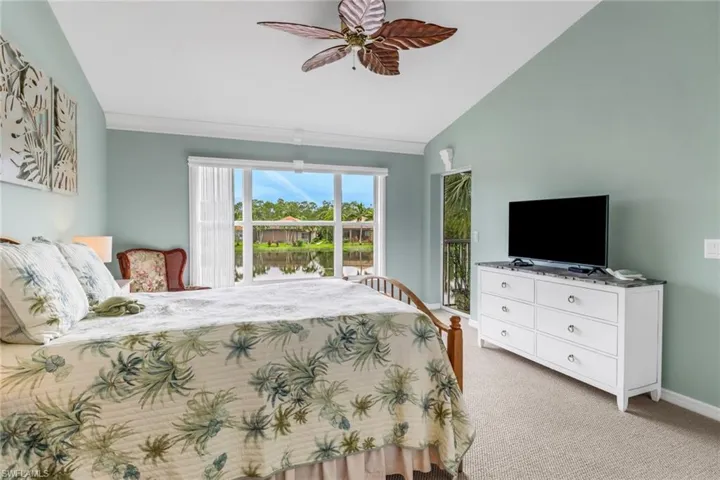 Bedroom with light colored carpet, access to outside, ceiling fan, and high vaulted ceiling