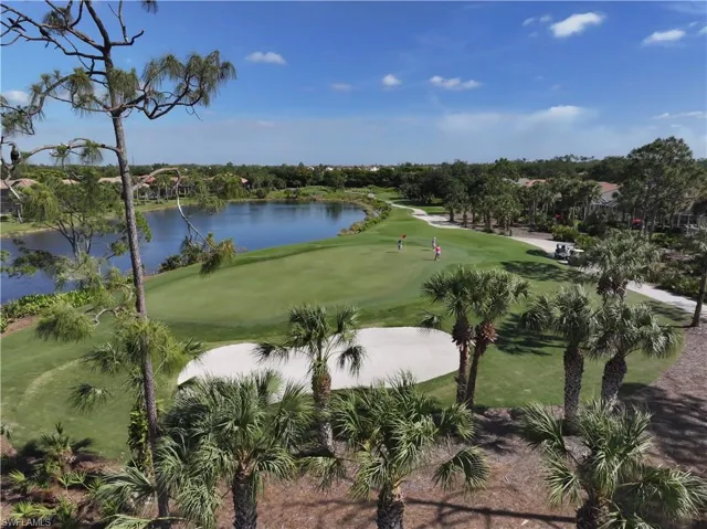 View of home's community with view of golf course, a water view, and view of scattered trees