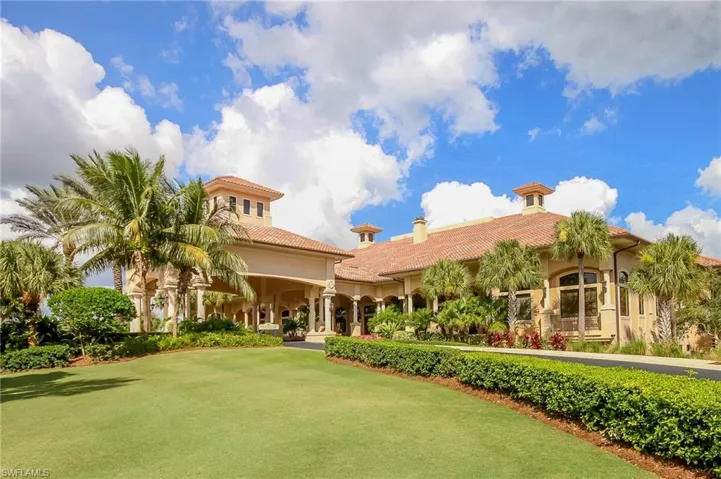 View of front of property featuring a tiled roof, stucco siding, a chimney, and a front yard