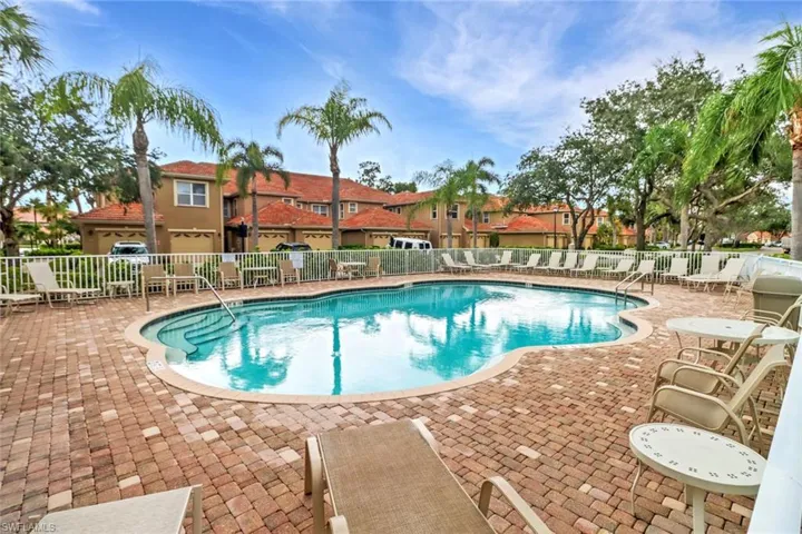 Community pool with a patio area and a residential view