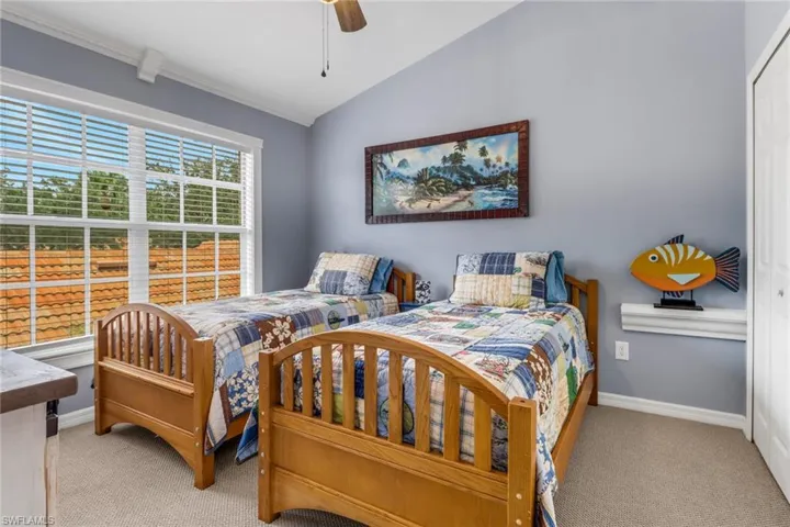 Bedroom with carpet floors, lofted ceiling, a ceiling fan, and crown molding