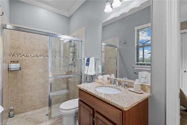 Bathroom with vanity, ornamental molding, and a stall shower