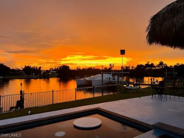 Patio terrace at dusk featuring a water view
