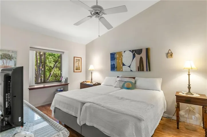 Bedroom with ceiling fan, lofted ceiling, and wood-type flooring