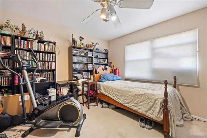 Carpeted guest bedroom featuring a ceiling fan