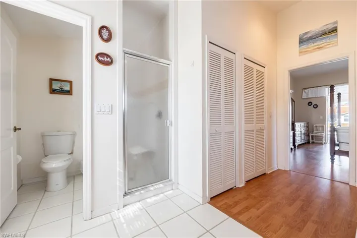 Primary Bathroom featuring a closet, light tile patterned flooring, and a shower stall