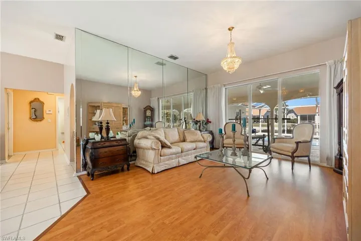 Living room featuring light wood-style flooring and suspended lighting