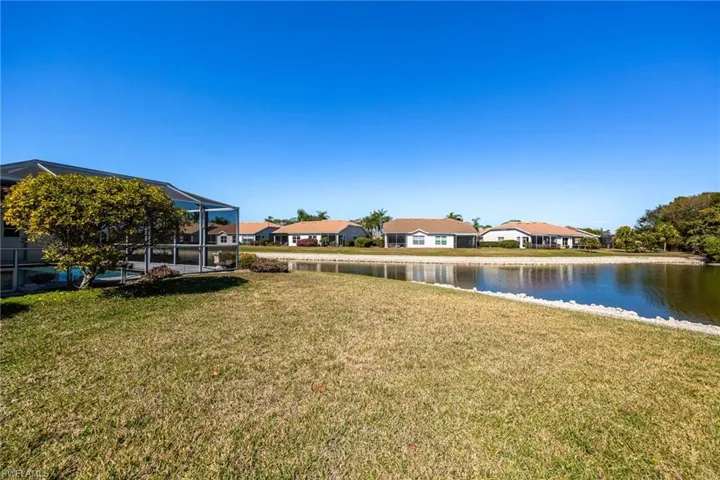 View of grassy yard featuring a residential view, a lanai, a sunroom, a water view, and a swimming pool