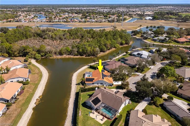 Aerial view of property and surrounding area with nearby suburban area and a large body of water