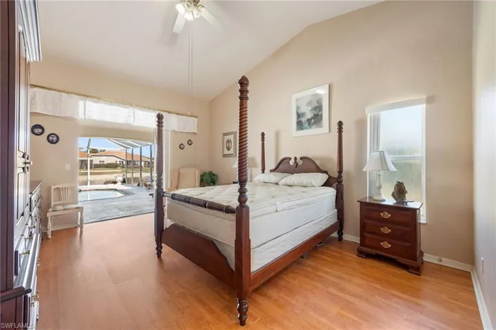 Primary Bedroom with access to exterior, vaulted ceiling, light wood finished floors, ceiling fan, and a sunroom