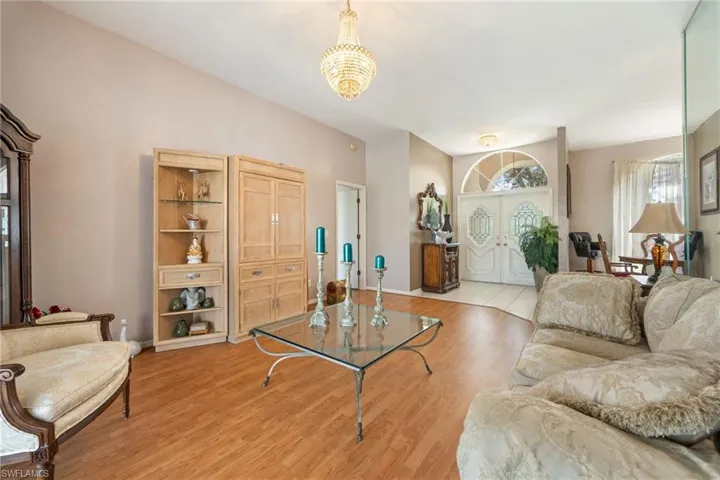 Living area with light wood-style floors and suspended lighting