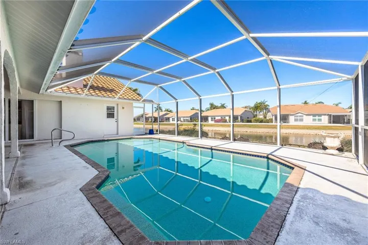 Swimming pool with a sunroom, a residential view, a patio area, and a lanai