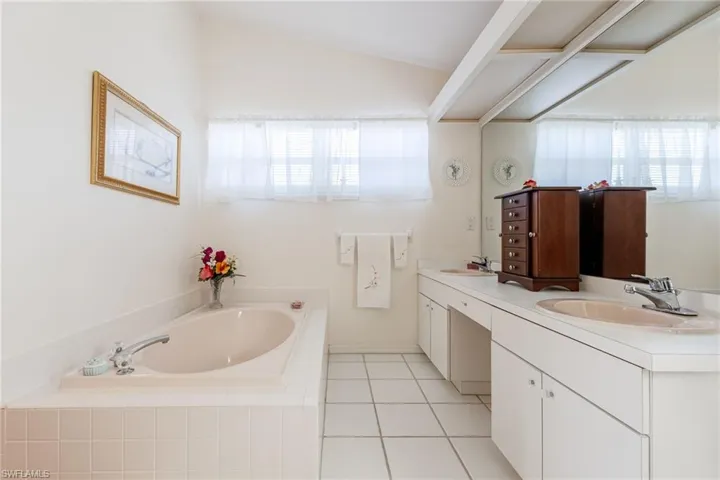 Primary bathroom, Full bathroom featuring double vanity, a garden tub, and light tile patterned floors