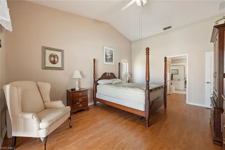 Primary Bedroom with lofted ceiling, light wood-style floors, and a ceiling fan