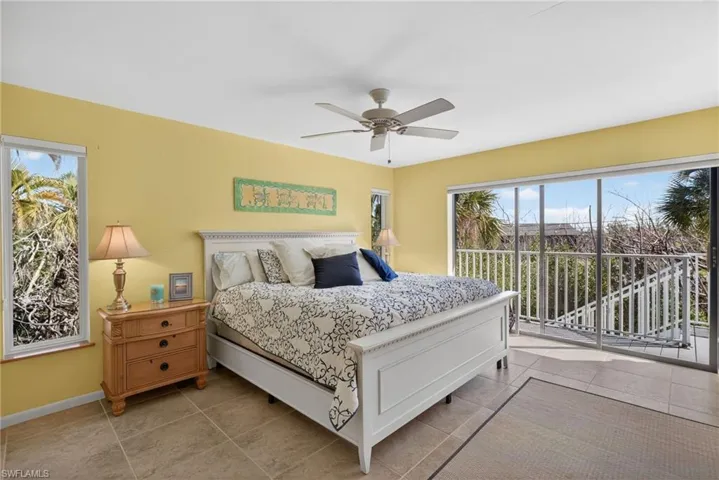 Bedroom featuring tile patterned floors, access to exterior, and multiple windows