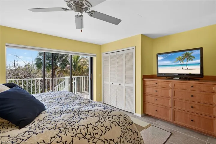 Bedroom featuring a ceiling fan, access to exterior, a closet, and light tile patterned floors