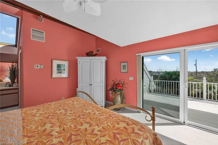 Primary Bedroom featuring multiple windows, access to exterior, ceiling fan, and lofted ceiling