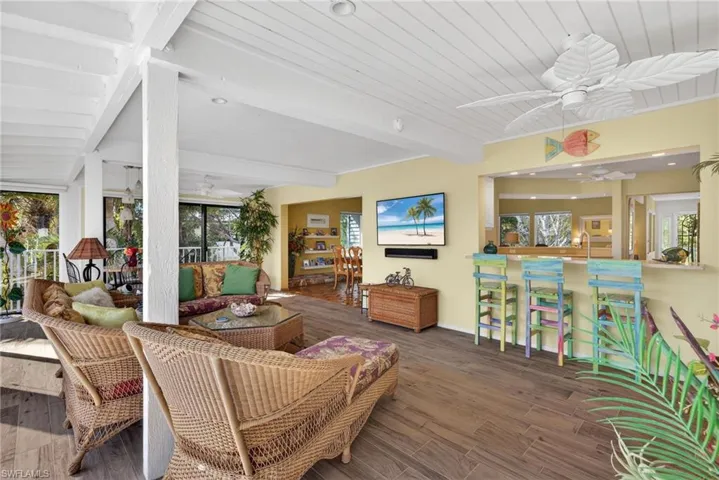 Family Room featuring ceiling fan, wood finished floors, plenty of natural light, a wooden ceiling with exposed beams, and a sunroom
