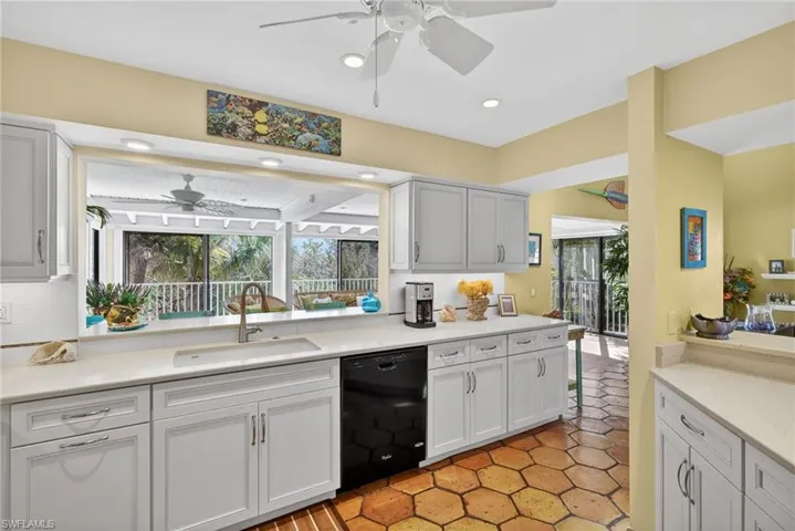 Kitchen with ceiling fan, dishwasher, light stone countertops, healthy amount of natural light, and recessed lighting