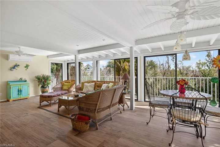 Family Room featuring ceiling fan, an outdoor hangout area, beamed ceiling, and a wall of windows