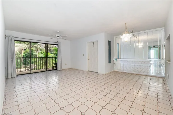 Living room featuring light floors, a ceiling fan, and a chandelier