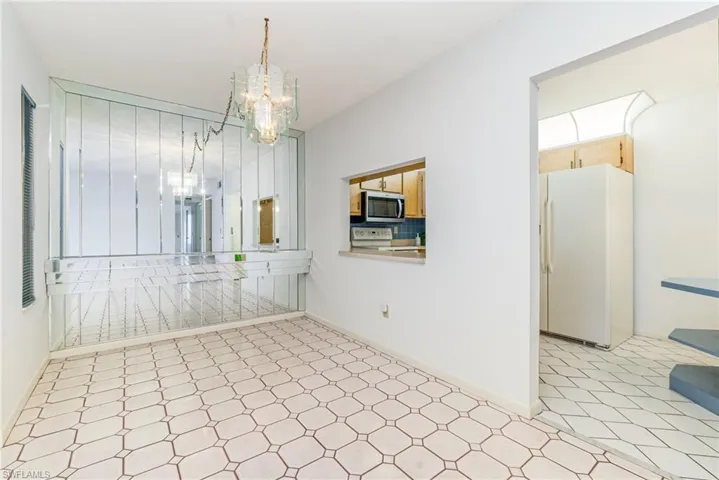 Unfurnished dining area with a chandelier and light flooring