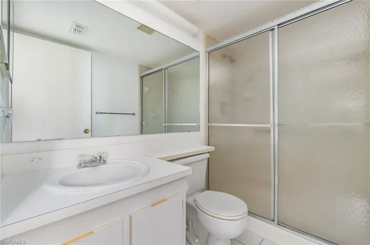 Full bath with vanity, a shower stall, and tile patterned floors