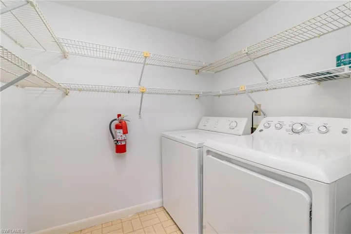 Laundry area featuring washer and clothes dryer and baseboards