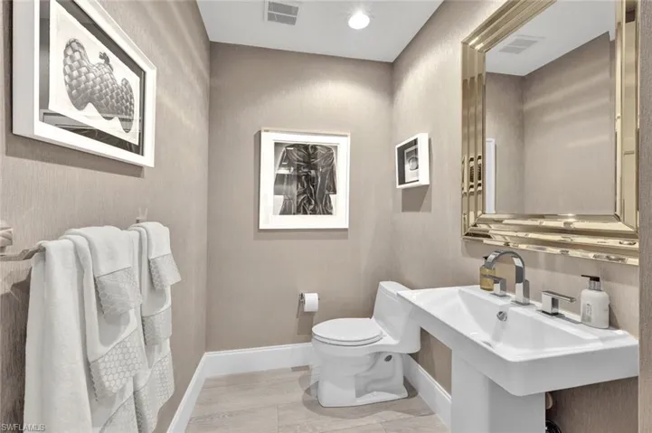 The powder room is perfectly located in the hallway just behind the kitchen.