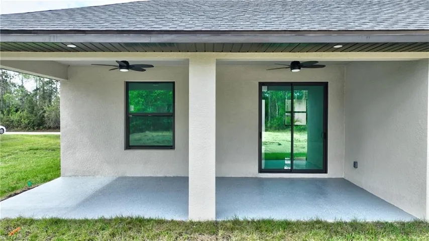 Property entrance featuring a patio area, a yard, and ceiling fan